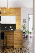 Modern, open-plan wooden kitchen in period building with Italian tiled floor