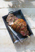 Hay-baked stuffed leg of lamb