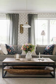 Rustic coffee table with antique wooden trough in front of sofa in living room