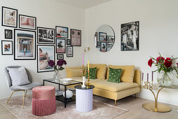 Gelbes Sofa mit Samtbezug, darüber Fotogalerie