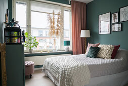 Double bed in guest room with dark matt green walls