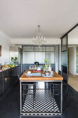 Industrial-style kitchen with glass and steel walls and black floor