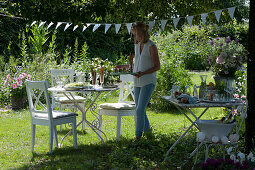 Frau deckt den Tisch im Garten