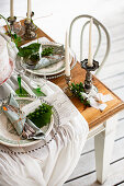 Gathered tablecloth and silver candlesticks on festively set table