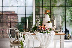 Two celebration cakes on set country-house table in industrial building