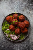 Traditional Middle eastern dish falafel served with fresh green cilantro and onion salad