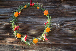 Scented wreath of rosemary branches decorated with shapes cut out of orange peel