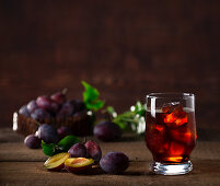 Plum drink with ice cubes and fresh plums