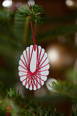 Selbstgemachter Christbaumanhänger aus mit Garn umwickeltem Papier