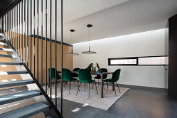 Dark green velvet chairs at long table in modern dining room