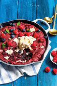 Berry gratin with vanilla ice cream in an oven pan