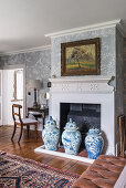 Urns in front of a fireplace in a bedroom with 1930s Art Deco-stlye chinoiserie wallpaper