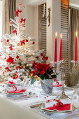 Festlich gedeckter Tisch und Weihnachtsbaum in Rot und Weiß
