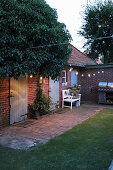 Courtyard garden lit by fairy lights at twilight