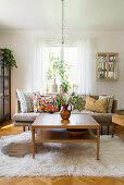 Coffee table on flokati rug and sofa with scatter cushions in living room