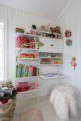 An open shelf in a girl's bedroom with white wood panelling