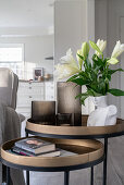 Books, lanterns and flowers on a two-part side table