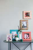 Pictures in decorated frames on and above console table