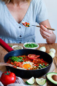 Various ingredients and fresh shakshuka with eggs and vegetables