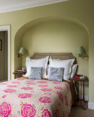 Pink floral quilted cover on bed in Victorian home