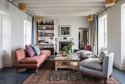 Beamed ceiling and furniture in living room of renovated 17th century stone cottage