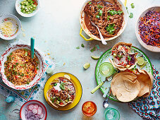Verschiedene mexikanische Gerichte (Reis, Chili-Taco-Cups mit Rindfleisch, Rotkohl-Chili-Salat)