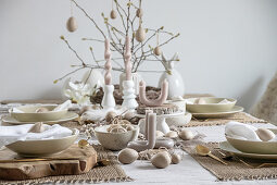 Artistically twisted and curved candles on table set for Easter meal