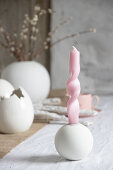 Artistically twisted candles on table set for Easter meal