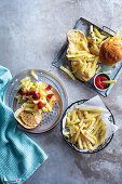 Pommes Frites serviert mit weichen Brötchen, Essig, Salz und Pfeffer oder Tomatensauce