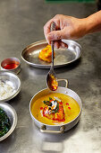 Malabar Seeteufel-Curry mit Öl beträufeln