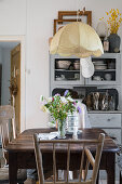 Wooden table below pendant lamp in rustic kitchen