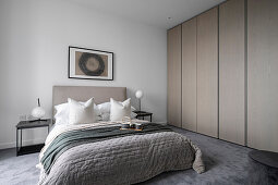 Modern bedroom in gray tones with a built-in wardrobe