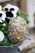 Viola planted in metal bucket with egg covered in willow catkins