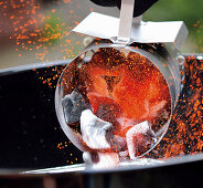 Pouring red-hot coal from a fire starter into the grill