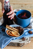 Mulled wine arranged on table with aromatic cinnamon sticks and dried oranges