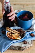 Glühwein mit Zimtstangen und getrockneten Orangen