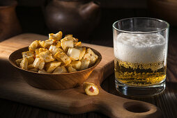 Gratinated diced cheese with a glass of beer