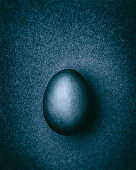 Blue-gray Easter egg on a gray-blue background