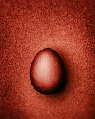 Rust-red Easter egg on a rust-red background