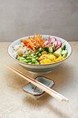 Vegan 'sushi' bowl with nori flakes and peanut sauce