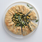 A round cheese and herb pie with apples and sage