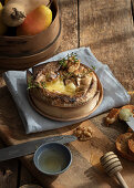 Baked camembert with walnuts on wooden table