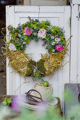 Summer wreath of roses, lady's mantle and straw