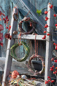 Wreaths of switchgrass, wild reed, and Chinese reed on a wooden ladder, twigs with rose hips and snail shells as decoration