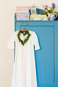 Nostalgic nightgown and a heart-shaped wreath on blue cupboard