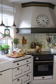 Clock on mantel hood in vintage-style kitchen