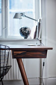 Desk with lamp in front of window