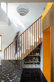 Storage shelves below stairs in open-plan kitchen