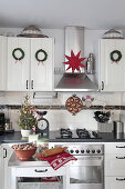Weihnachtlich dekorierte Landhausküche mit Kränzen und Stern
