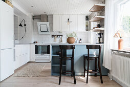 White fitted kitchen with breakfast bar and bar stools